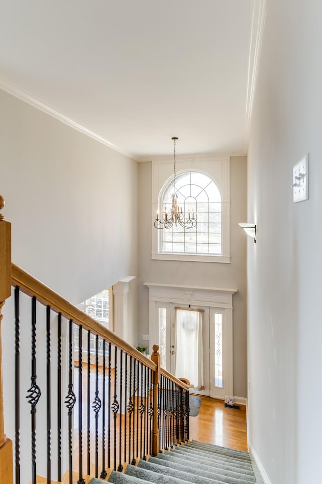 entryway featuring a notable chandelier, wood-type flooring, and crown molding