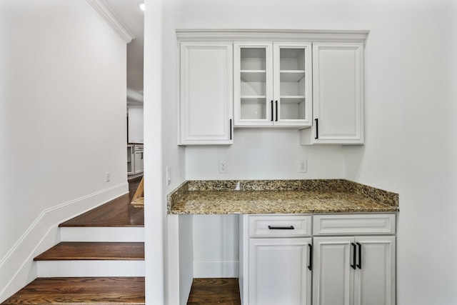 interior space featuring white cabinets, dark wood-type flooring, and dark stone counters