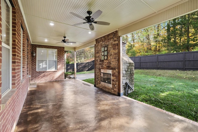 view of patio with an outdoor stone fireplace and ceiling fan