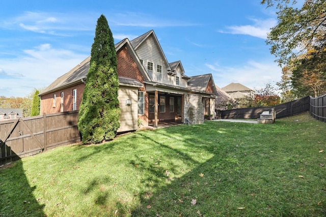 rear view of house featuring a yard