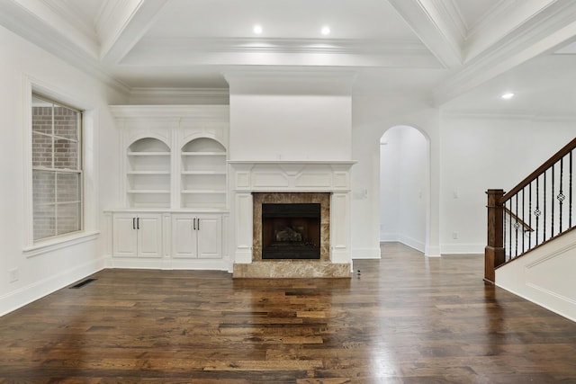 unfurnished living room featuring a premium fireplace, beamed ceiling, and dark hardwood / wood-style floors