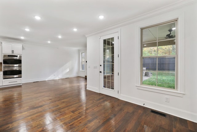 interior space featuring ceiling fan, dark wood-type flooring, and ornamental molding