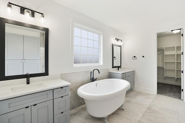 bathroom featuring vanity, a bathtub, tile patterned floors, and tile walls