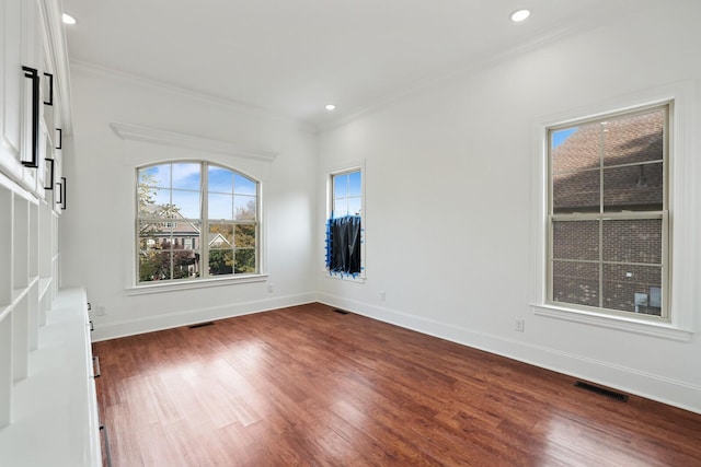 empty room with hardwood / wood-style floors and ornamental molding