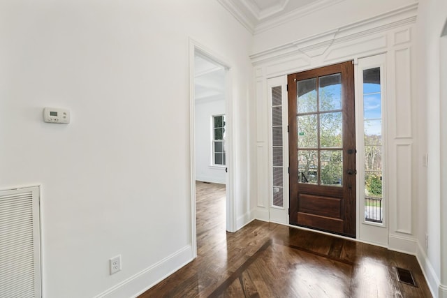 foyer featuring dark wood-type flooring, a healthy amount of sunlight, and ornamental molding