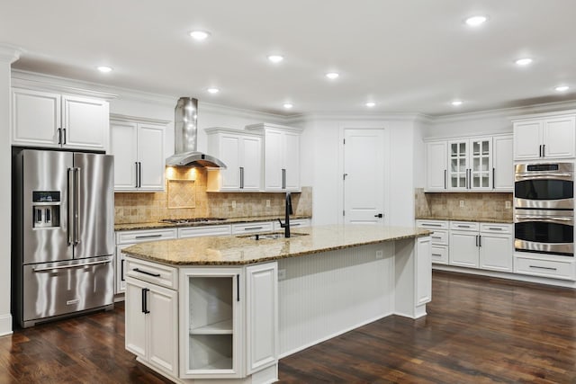 kitchen featuring dark hardwood / wood-style floors, wall chimney range hood, stainless steel appliances, and an island with sink