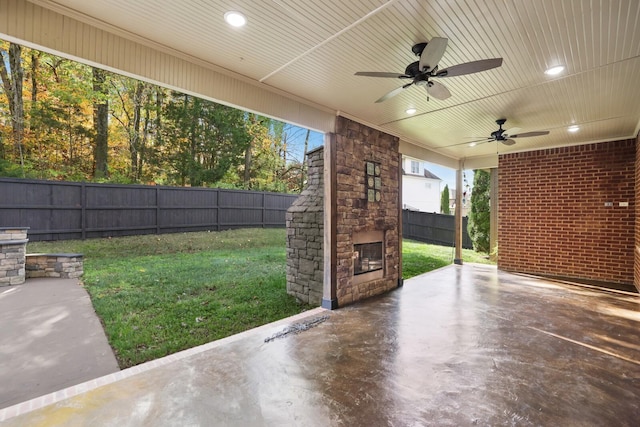 view of patio with ceiling fan and an outdoor stone fireplace