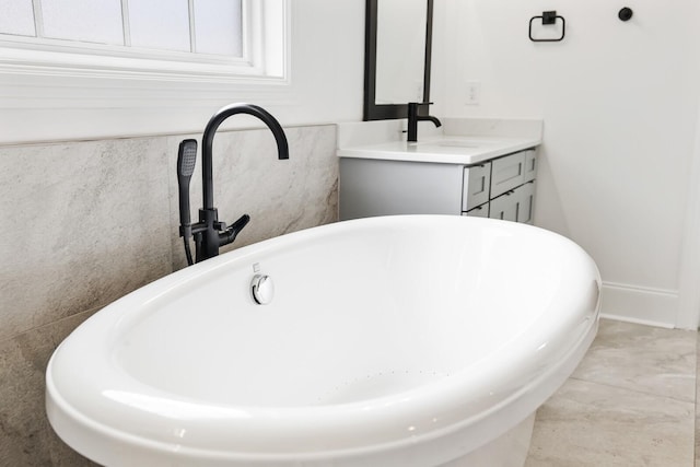 bathroom with tile patterned floors, vanity, and a bath