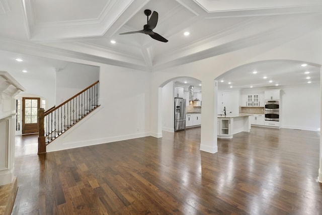 unfurnished living room featuring dark hardwood / wood-style flooring, ceiling fan, crown molding, and sink