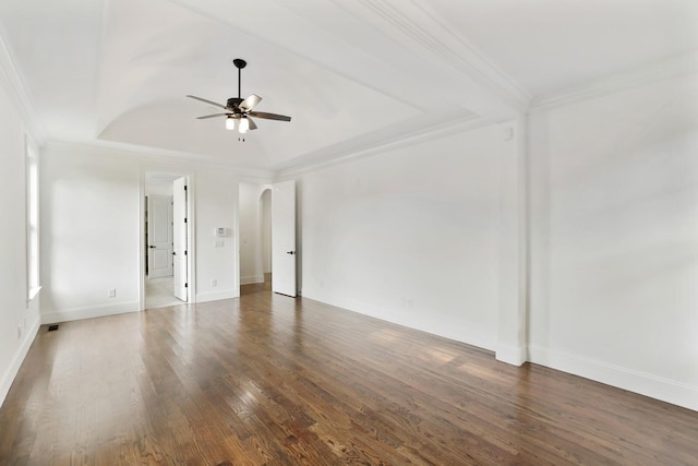 spare room featuring ceiling fan, a raised ceiling, ornamental molding, and dark wood-type flooring