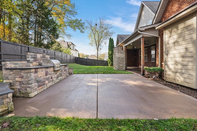 view of patio / terrace with a grill, ceiling fan, and an outdoor kitchen