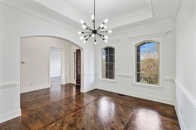 unfurnished room with a raised ceiling, ornamental molding, dark wood-type flooring, and a notable chandelier