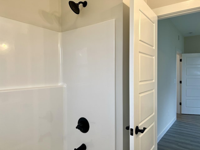 bathroom featuring bathtub / shower combination and hardwood / wood-style flooring