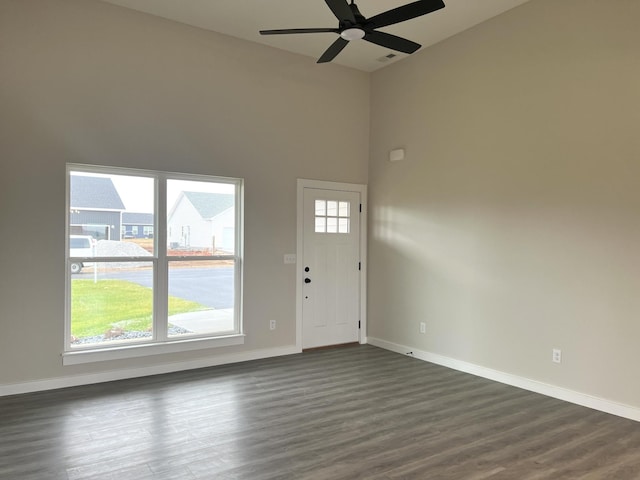 entryway with a towering ceiling, dark hardwood / wood-style flooring, and ceiling fan