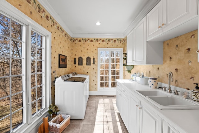 clothes washing area with cabinets, ornamental molding, sink, light tile patterned floors, and independent washer and dryer