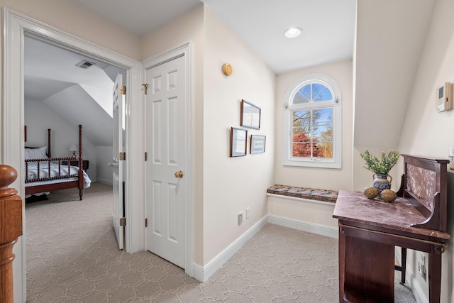 hall featuring light colored carpet and vaulted ceiling