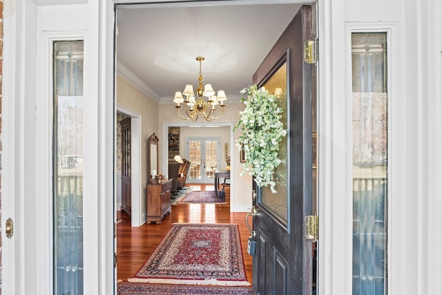 entryway with a chandelier, dark hardwood / wood-style flooring, crown molding, and french doors