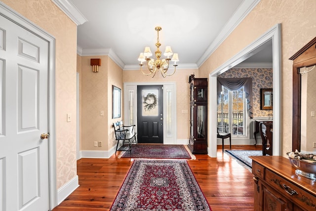 foyer with a chandelier, dark hardwood / wood-style floors, and ornamental molding