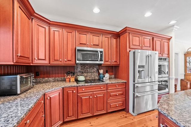 kitchen with tasteful backsplash, stainless steel appliances, crown molding, light hardwood / wood-style flooring, and stone counters