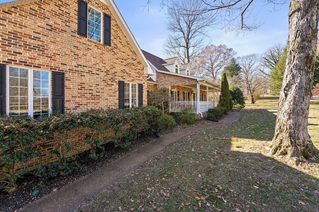 255 Parks Dr, Normandy, TN 37360 - view of side of home with brick siding, a porch, and a yard