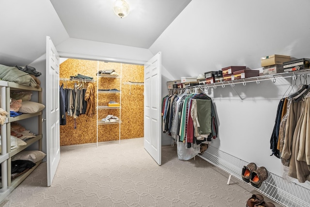 walk in closet featuring carpet and vaulted ceiling