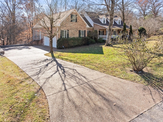 255 Parks Dr, Normandy, TN 37360 - view of front of home featuring a front lawn, concrete driveway, brick siding, and covered porch