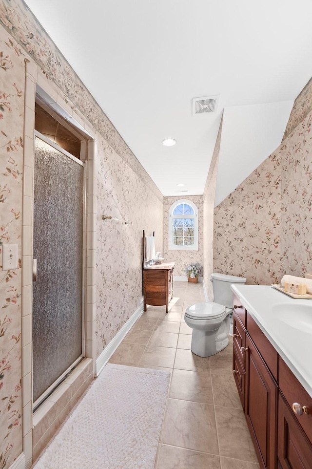 bathroom featuring tile patterned flooring, vanity, toilet, and walk in shower