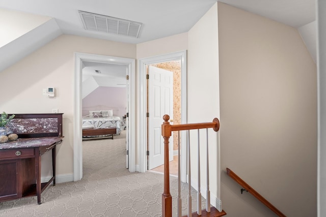 corridor with light colored carpet and lofted ceiling