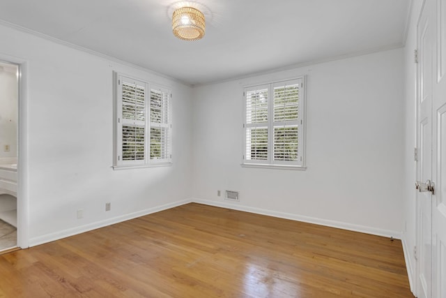 unfurnished bedroom featuring crown molding and light hardwood / wood-style flooring