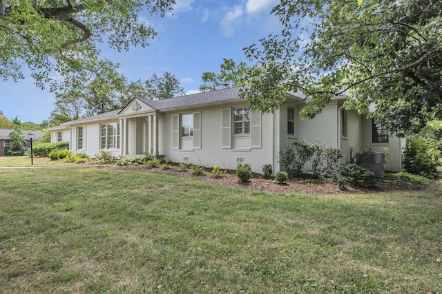 ranch-style house featuring a front lawn and cooling unit