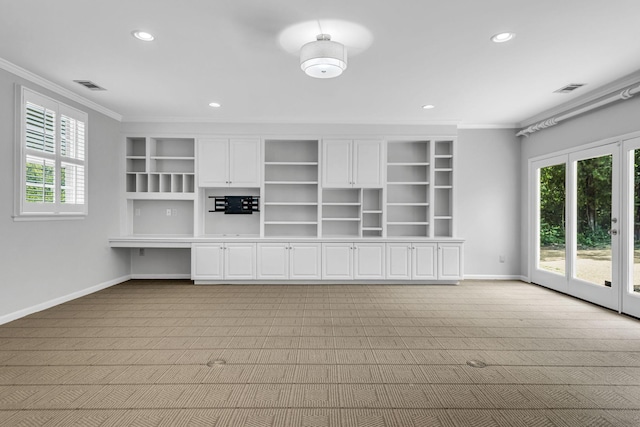 unfurnished living room featuring light colored carpet, a healthy amount of sunlight, and ornamental molding