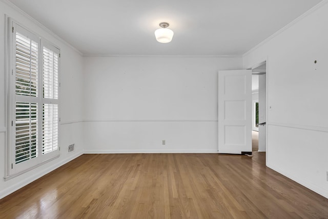 unfurnished room featuring a wealth of natural light, crown molding, and wood-type flooring