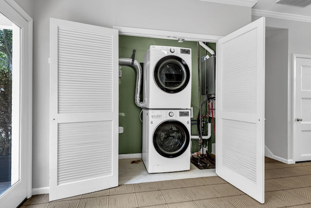 washroom with stacked washing maching and dryer and crown molding