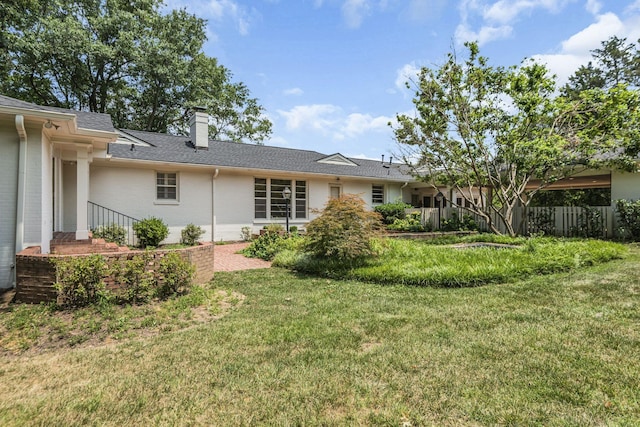 rear view of house featuring a lawn