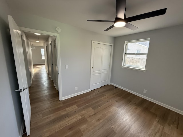 unfurnished bedroom featuring ceiling fan, a closet, and dark hardwood / wood-style floors