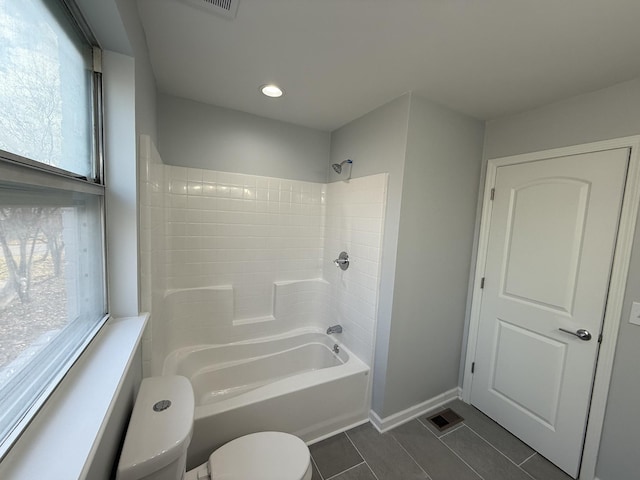 bathroom with plenty of natural light, toilet, and tub / shower combination