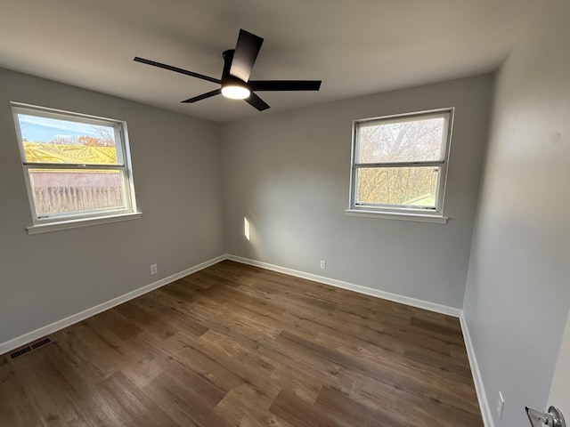 unfurnished room featuring ceiling fan and dark wood-type flooring