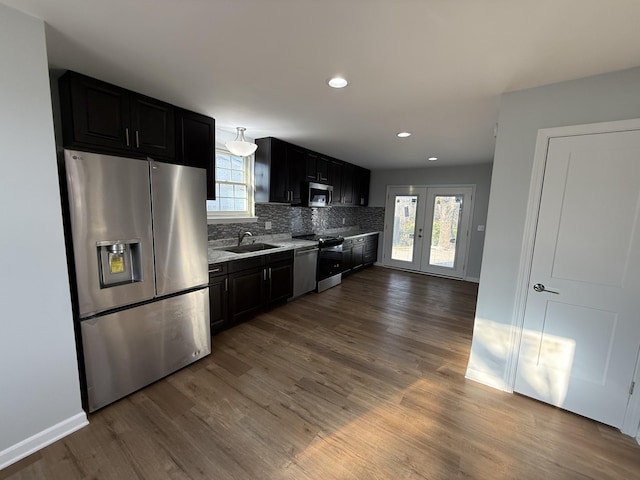 kitchen with plenty of natural light, wood-type flooring, appliances with stainless steel finishes, and french doors