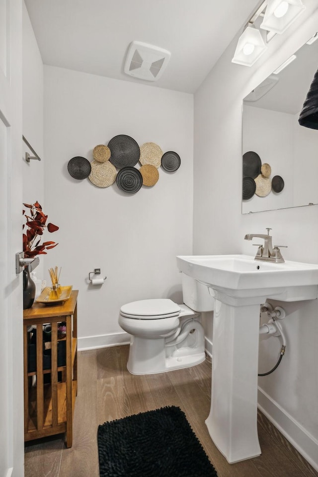 bathroom featuring hardwood / wood-style floors and toilet