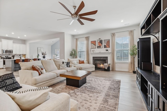 living room with ceiling fan and light hardwood / wood-style floors