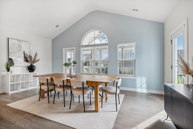 dining space with hardwood / wood-style floors and lofted ceiling