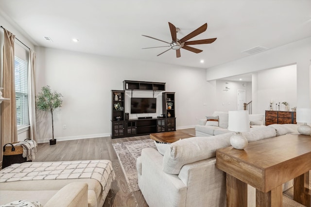 living room with ceiling fan and light hardwood / wood-style flooring