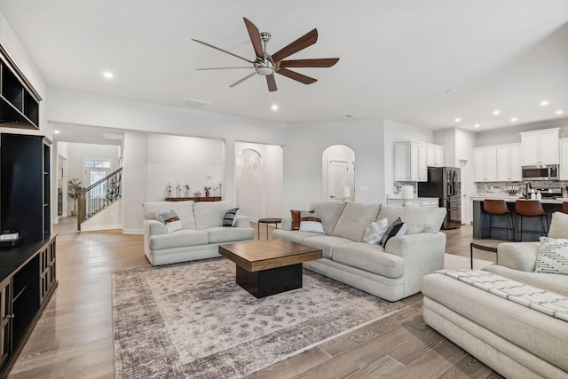 living room with ceiling fan and light hardwood / wood-style flooring