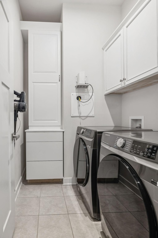 washroom with separate washer and dryer, light tile patterned flooring, and cabinets