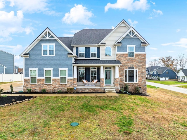 craftsman-style home featuring covered porch and a front yard