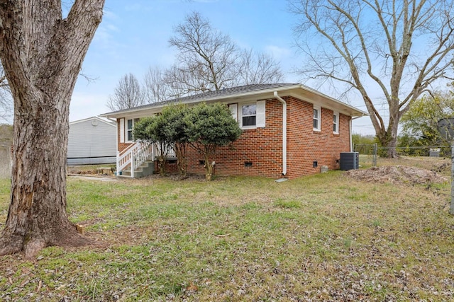 rear view of house with a lawn and cooling unit