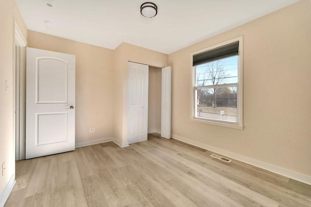 unfurnished bedroom featuring a closet and light hardwood / wood-style flooring