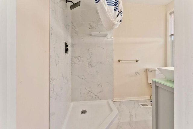 bathroom with tiled shower and vanity