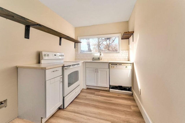 kitchen with light wood-type flooring, tasteful backsplash, white appliances, sink, and white cabinets