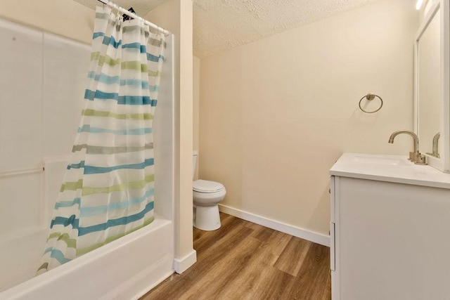 full bathroom featuring vanity, a textured ceiling, shower / bath combo with shower curtain, wood-type flooring, and toilet